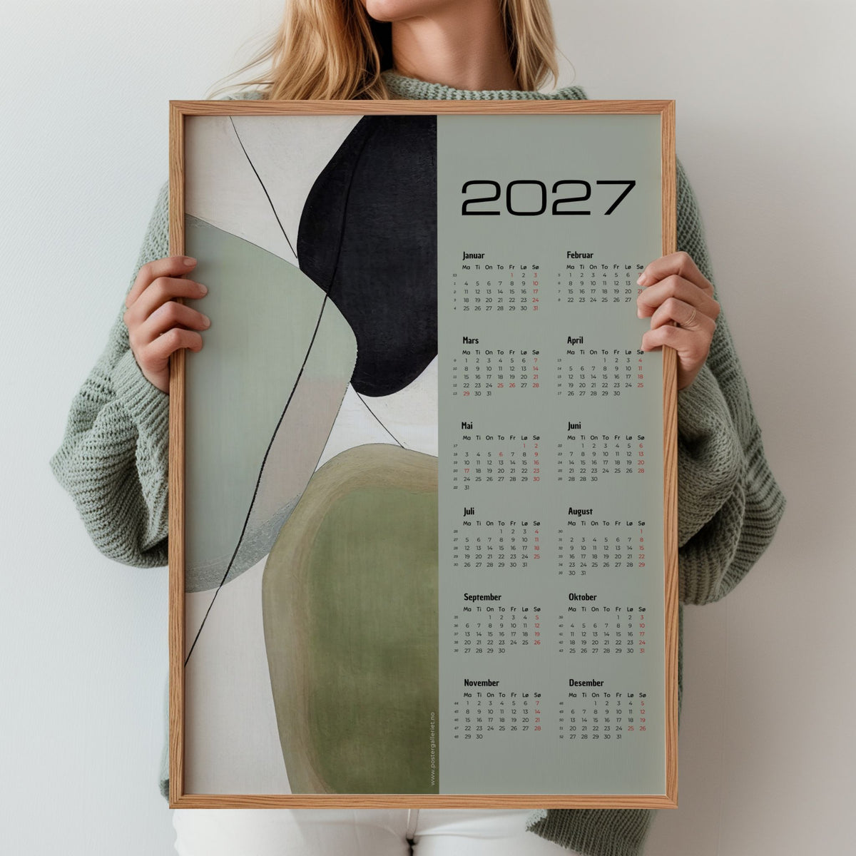 Kvinne holder grafisk veggkalender 2027 med Soft Balance-motiv