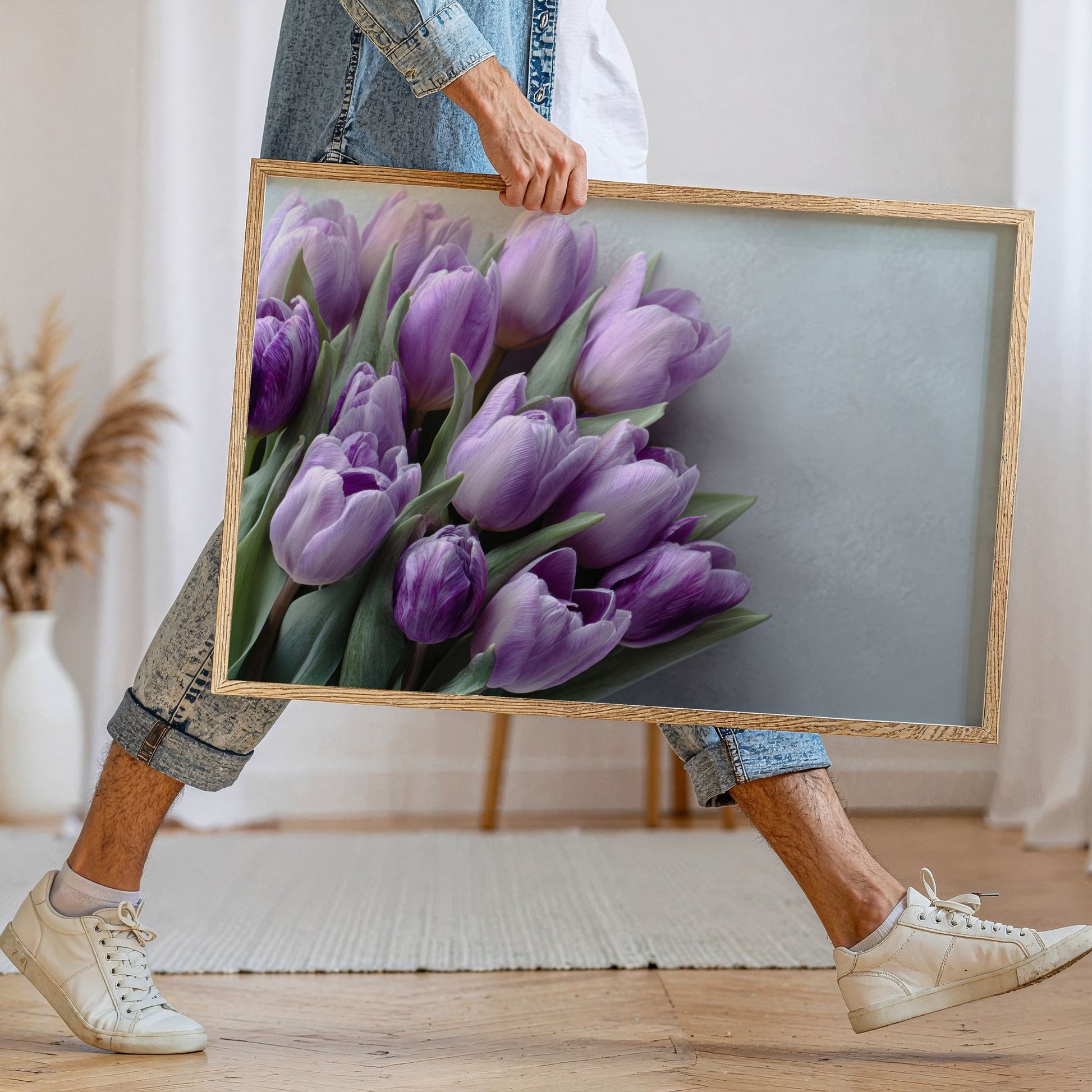 Person holder stor plakat med lilla tulipanbukett