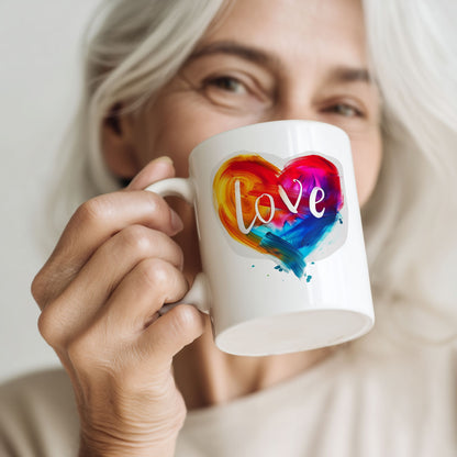 Kvinne holder Love in Color krus med fargerikt hjertemotiv og teksten Love.