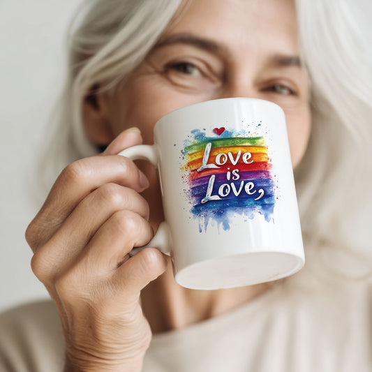 Kvinne holder keramikkrus med akvarellfarger i regnbuetoner og teksten Love is Love.