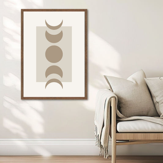 Lunar Harmony – geometrisk plakat med månefaser. Illustrasjon viser plakat i valnøtt ramme ved en sofa.