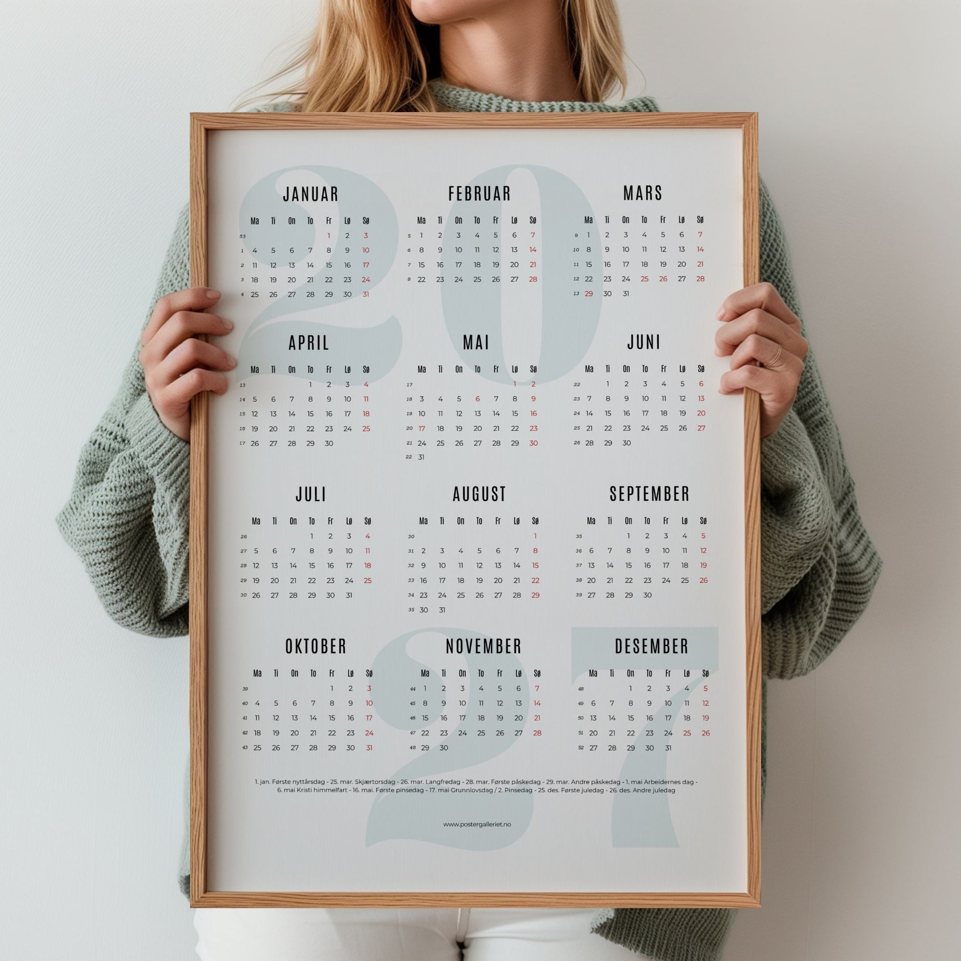 Minimalistisk kalender 2027 i treramme holdt av kvinne