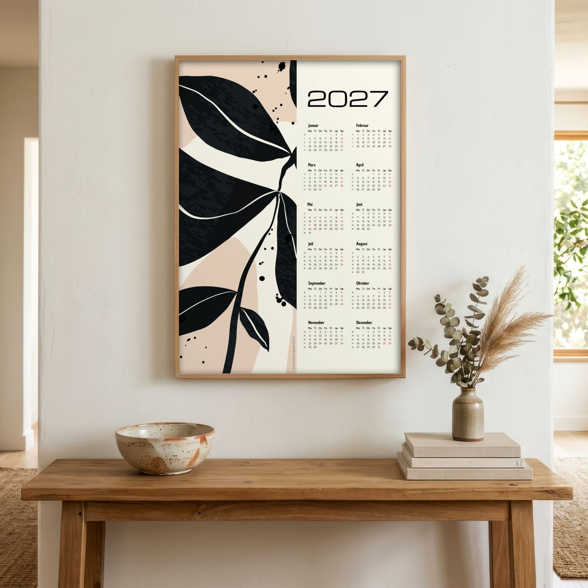 Monochrome Botanica grafisk veggkalender 2027 med sort botanisk motiv vist i lyst interiør
