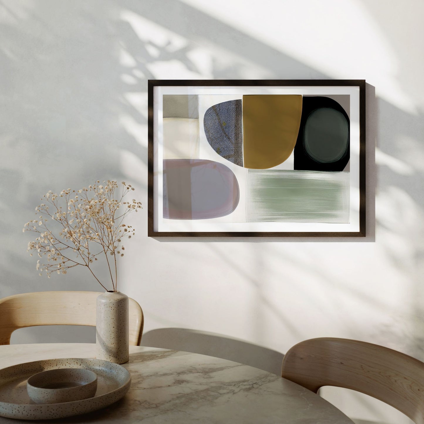 Natural Rhythm grafisk plakat i sort ramme over skjenk i moderne spisestue med varme naturmaterialer.