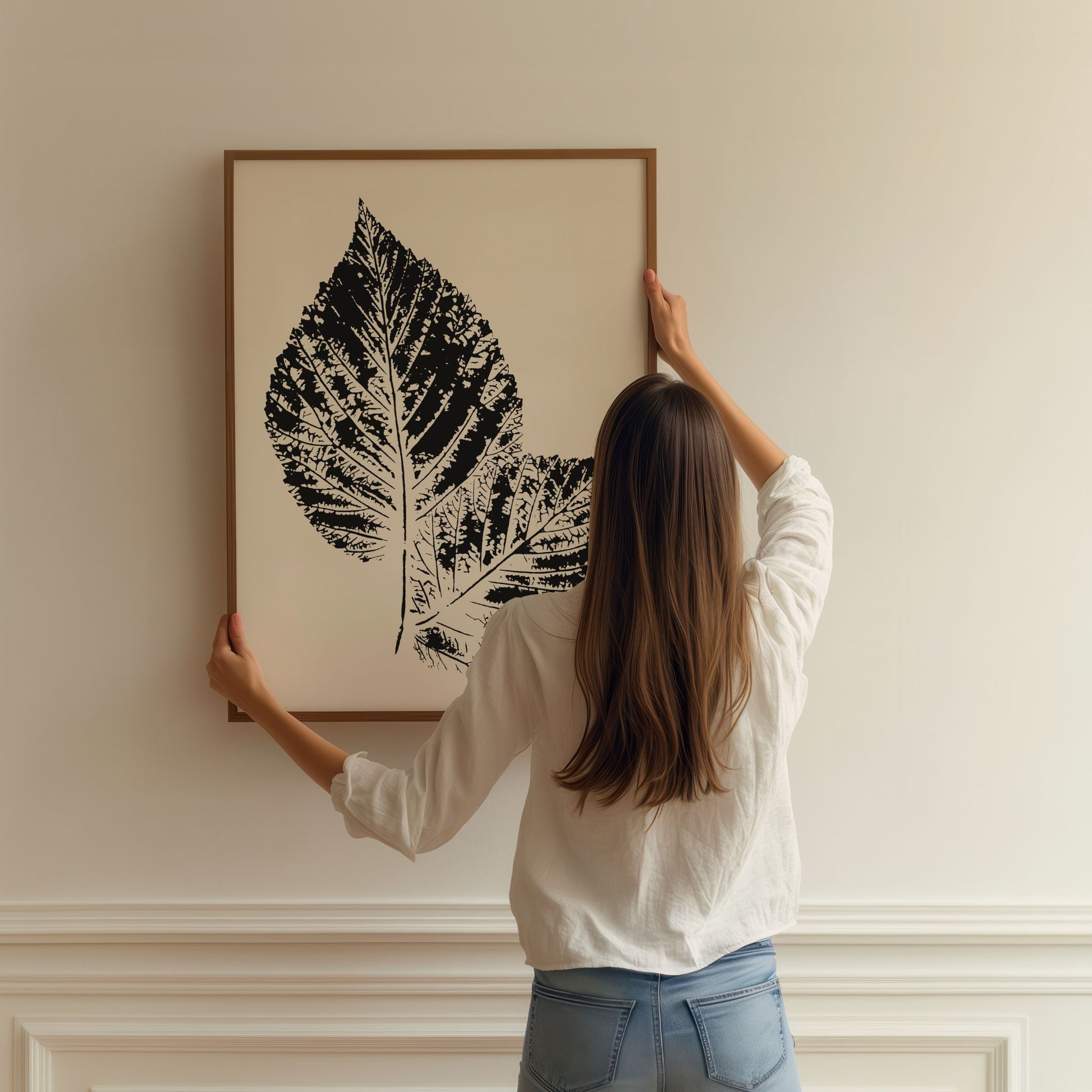 Person henger opp Nordic Botanical No2 på vegg i moderne hjem.