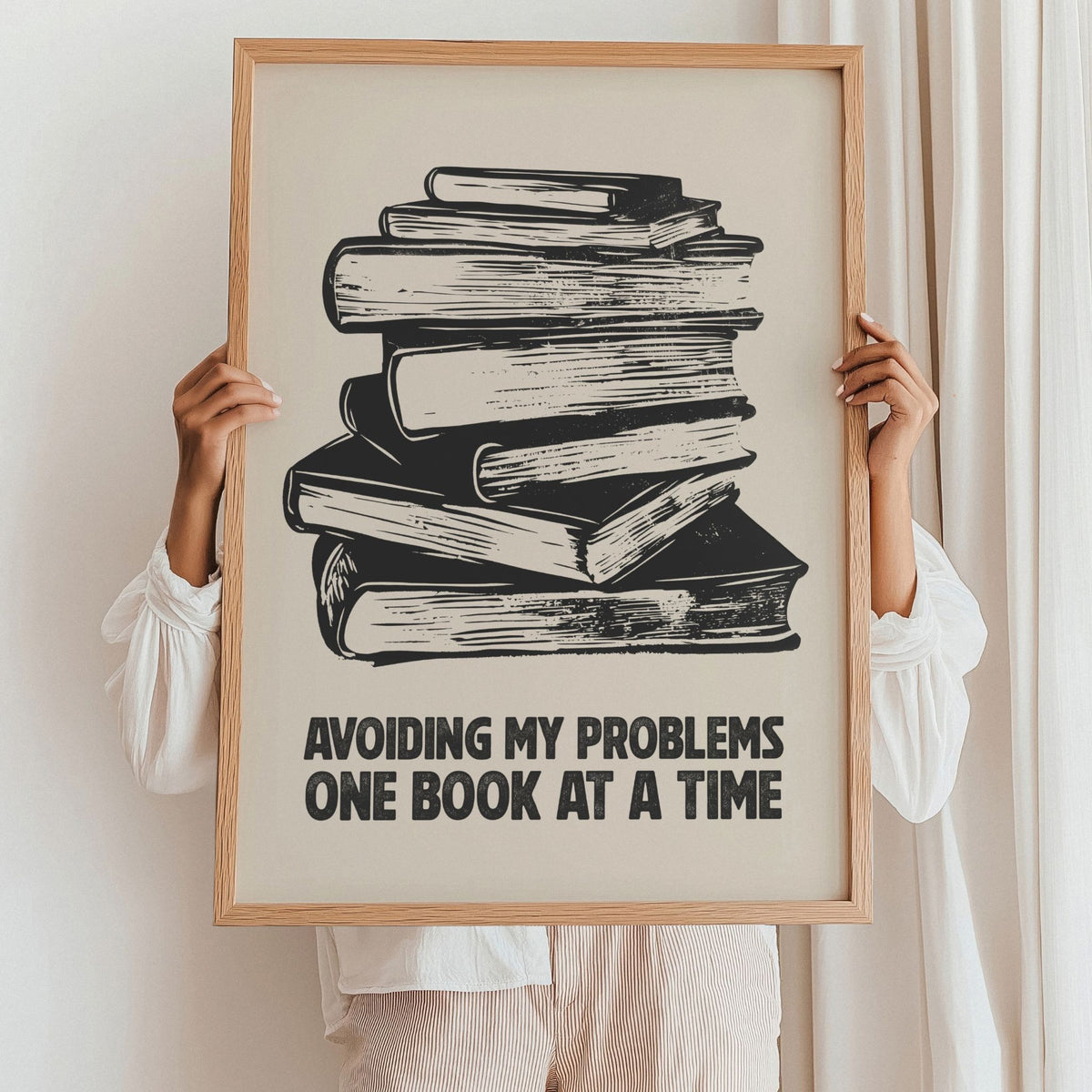 One Book at a Time kunstplakat holdt opp i eikeramme som inspirasjon til innramming