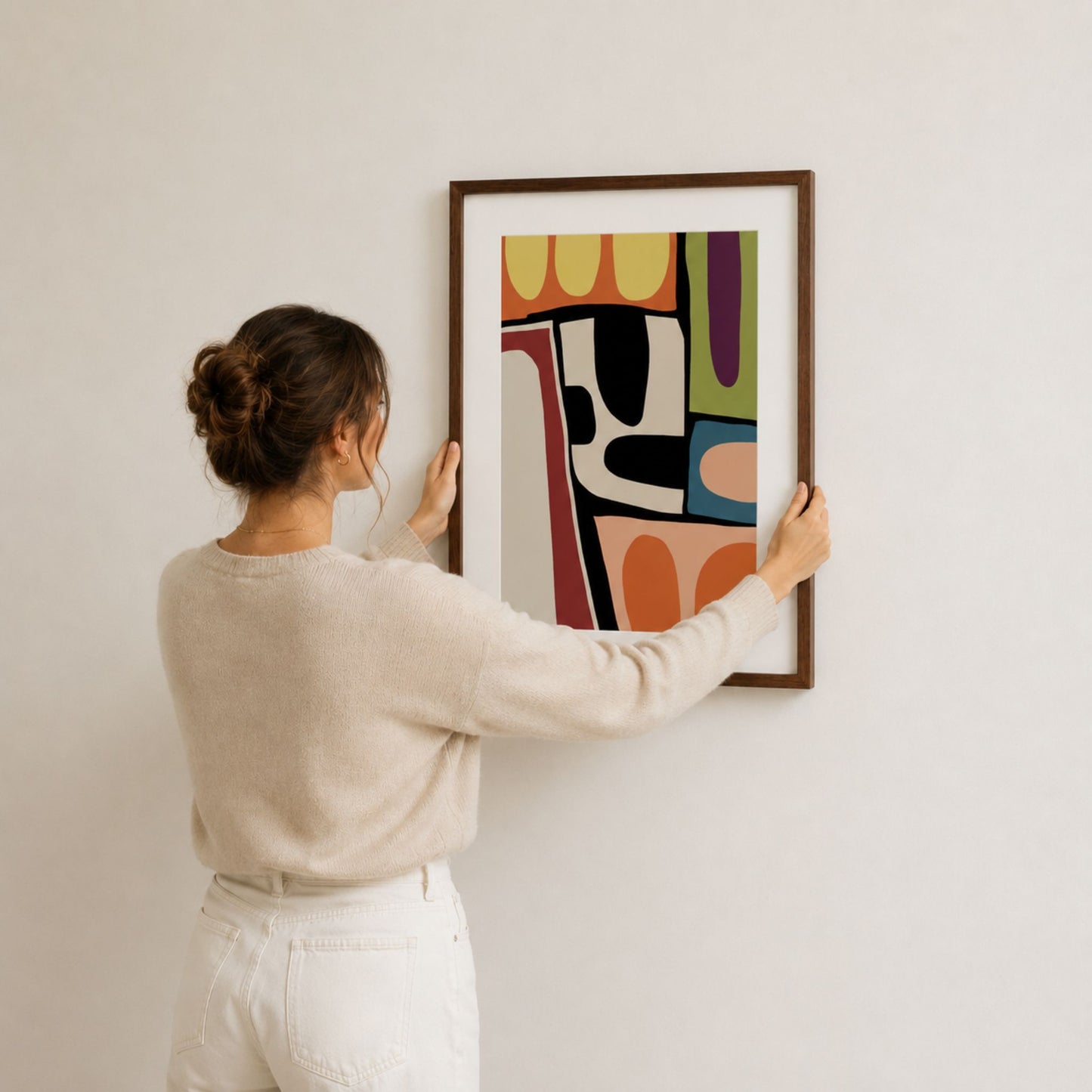 Kvinne henger opp Organic Mosaic No1 abstrakt plakat på lys vegg