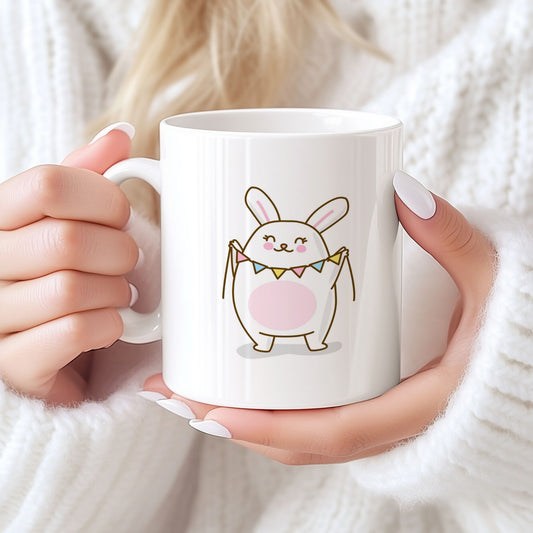 Hvitt keramikkrus med søt påskehare som holder vimpelrekke og teksten God påske på motsatt side. Kvinne holder krus.