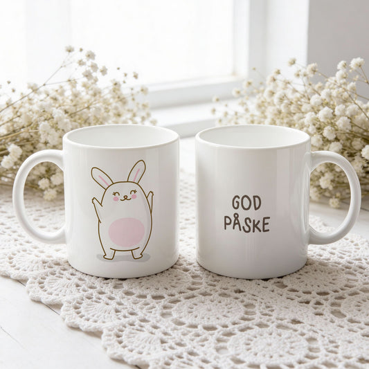 Hvitt keramikkrus med glad påskehare med løftede armer og teksten God påske på motsatt side.