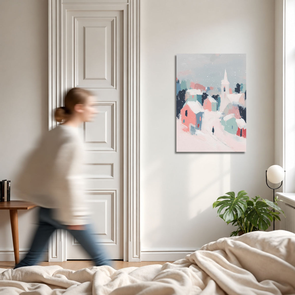 Pastell Winter Village vinterlerret på lys vegg i moderne interiør med person i bevegelse og grønn plante.