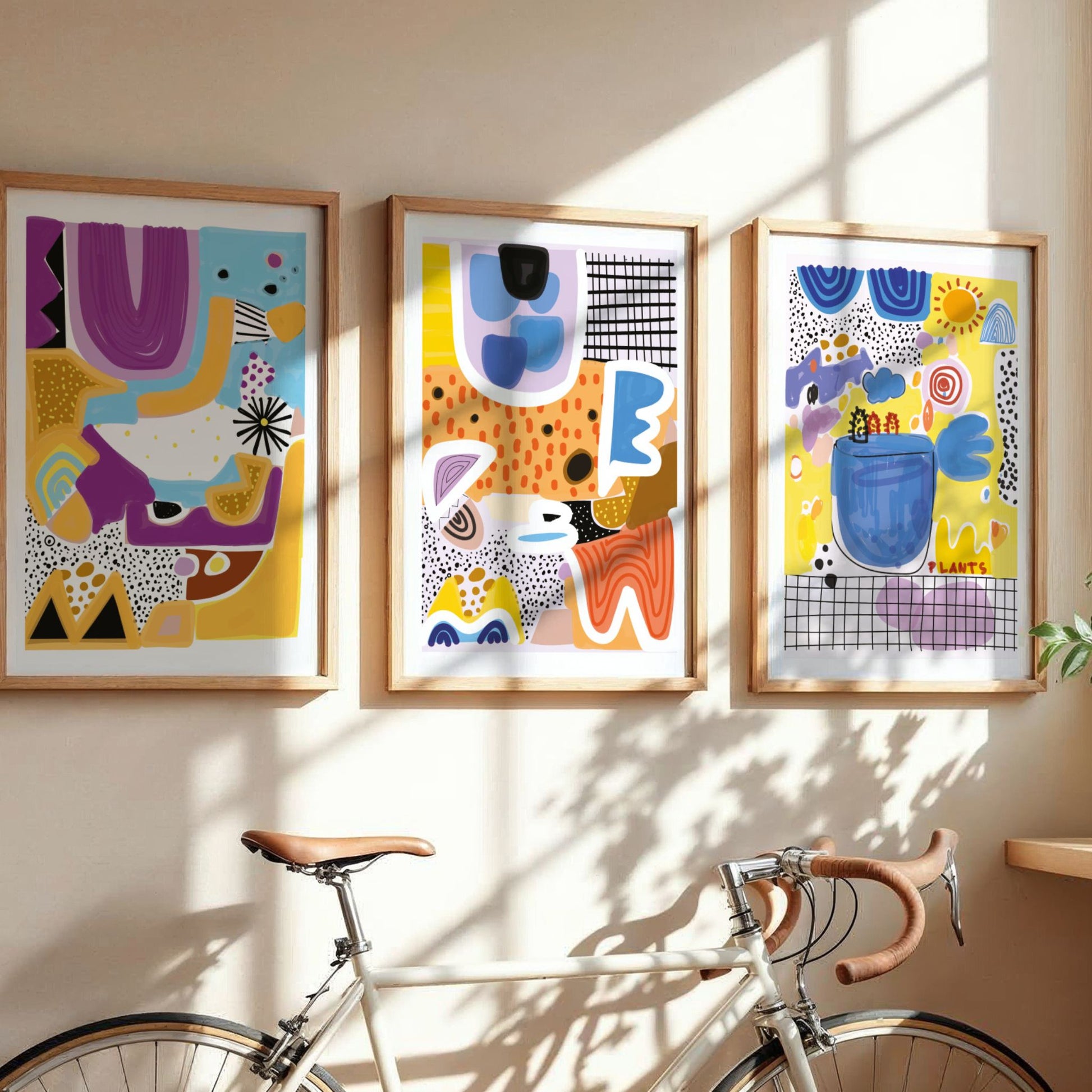 Playful Forms Trio med tre fargerike grafiske plakater i eikerammer i lyst interiør