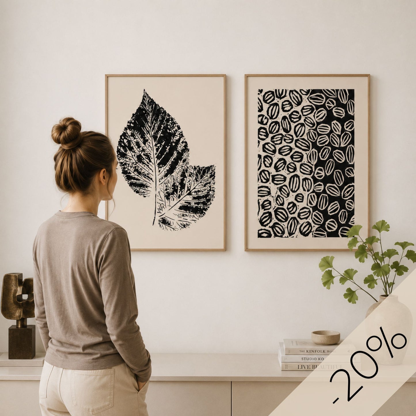 Grafisk plakatduo fra Soft Balance Collection i eikerammer med kvinne som betrakter motivene.