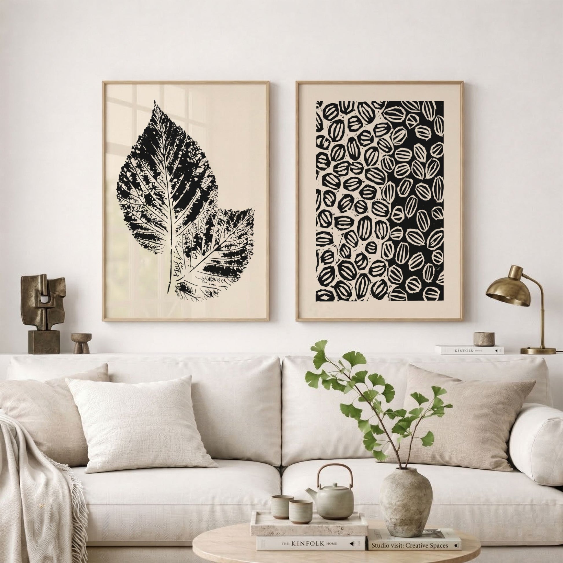 Grafisk plakatduo fra Soft Balance Collection i eikerammer over lys sofa.