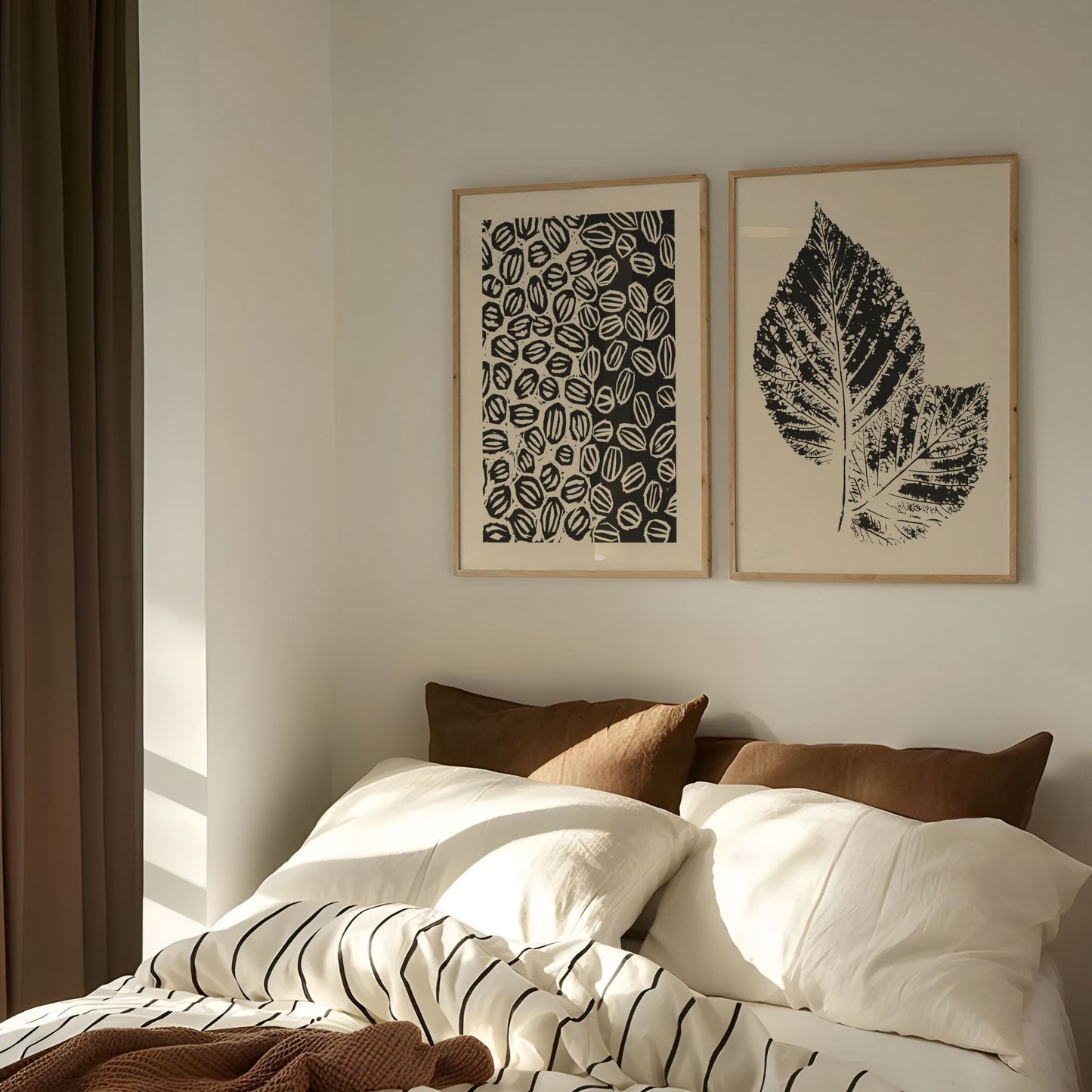 Grafisk plakatduo fra Soft Balance Collection i eikerammer over seng i lyst, skandinavisk soverom.