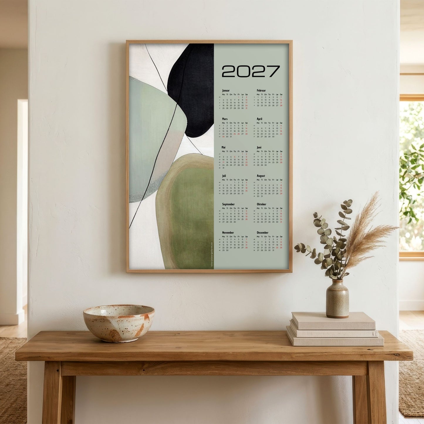 Soft Balance grafisk veggkalender 2027 vist i lyst interiør over trebord