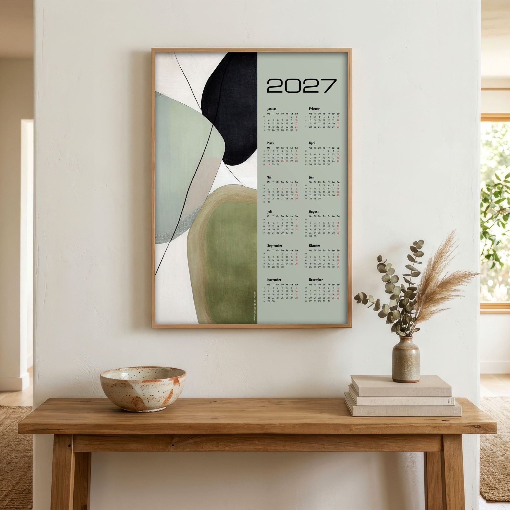 Soft Balance grafisk veggkalender 2027 vist i lyst interiør over trebord