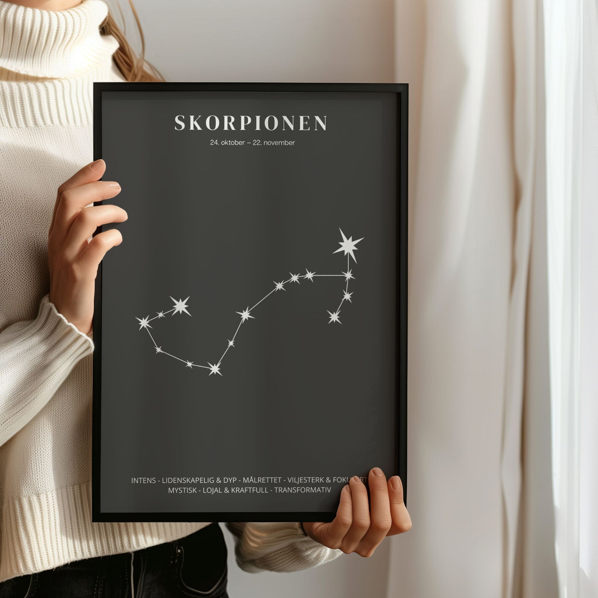 Minimalistisk stjernetegnplakat med stjernebildet Skorpionen i hvitt på sort bakgrunn. Person som holder ramme.