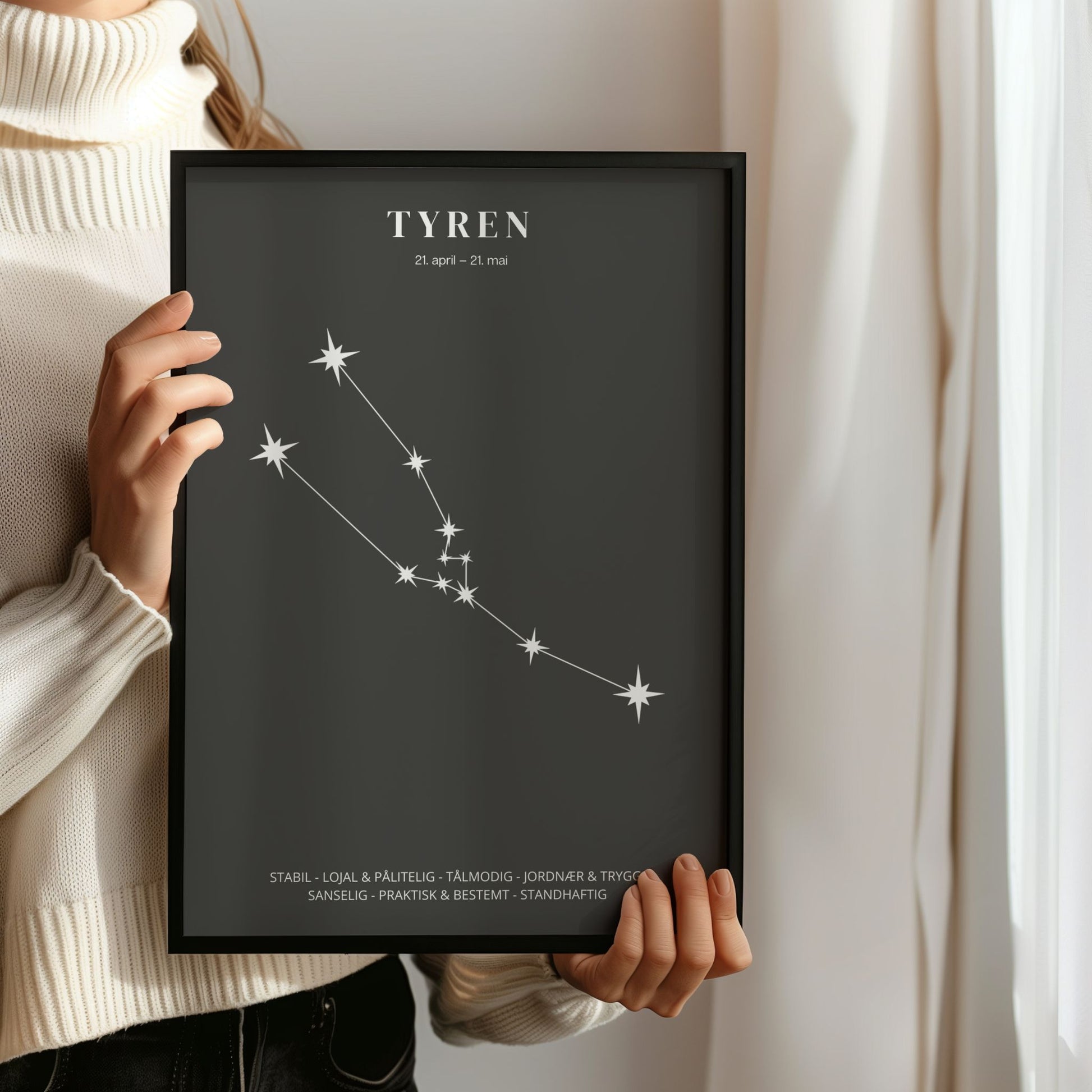 Minimalistisk stjernetegnplakat med stjernebildet Tyren i hvitt på sort bakgrunn. Person som holder ramme.