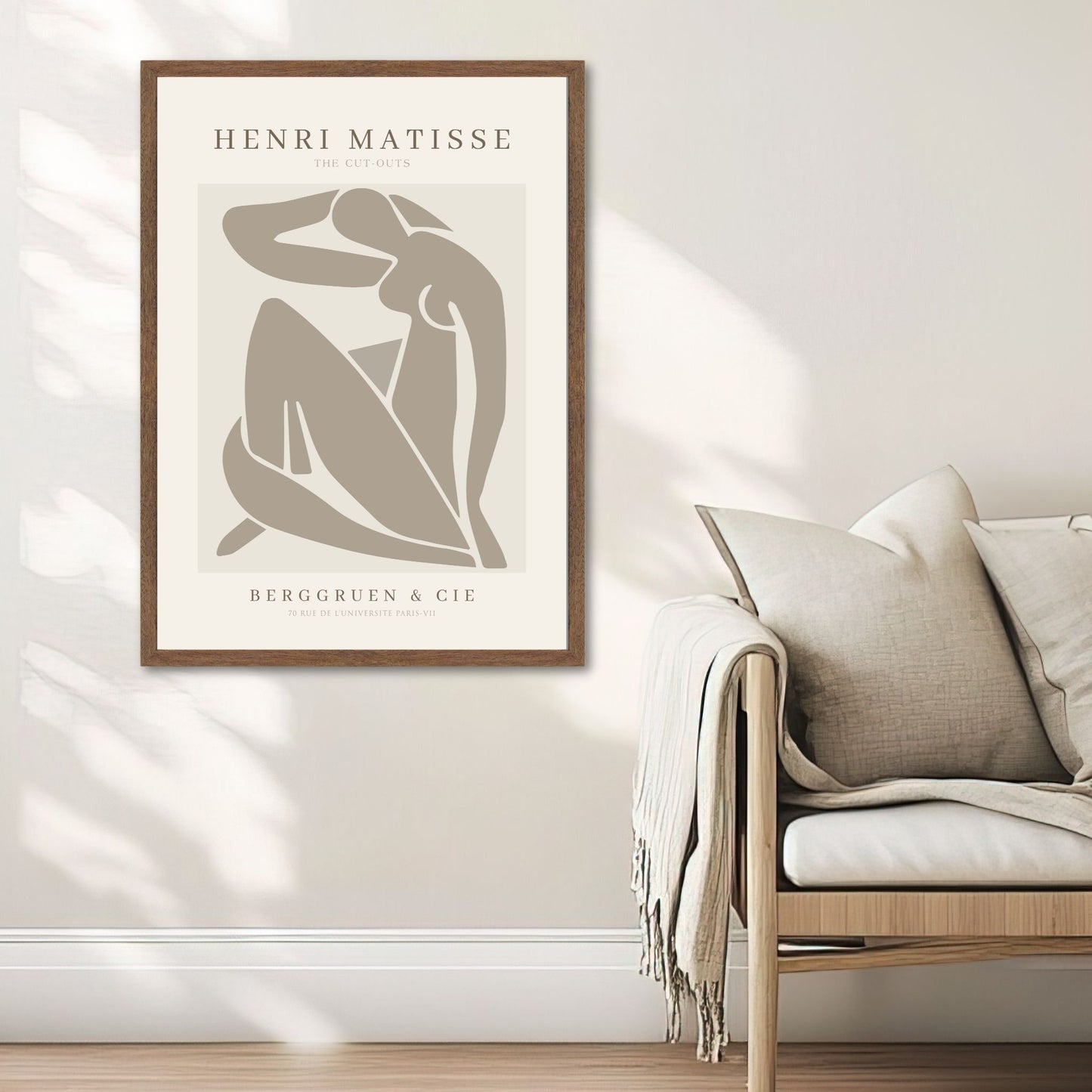 The Cut-Out Muse – Matisse-inspirert kunstplakat. Illustrasjon viser plakat i valnøtt ramme ved en sofa.