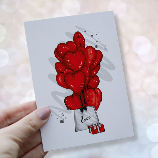 Romantisk valentineskort med røde hjerteballonger, gave og pose med teksten love, symbol på kjærlighet og omtanke. Kortet blir holdt i en hånd.