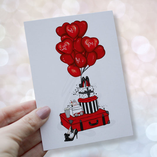 Illustrert valentineskort med røde hjerteballonger, gaver, parfyme og moteelementer i klassisk kjærlighetstema.Kortet blir holdt i en hånd.