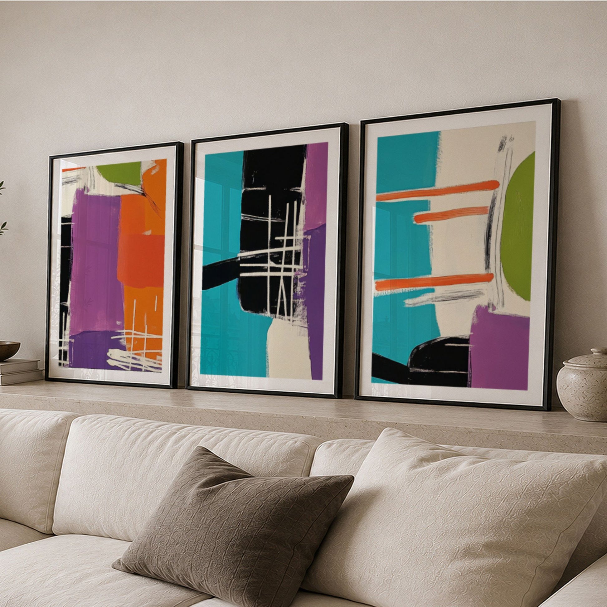 Tre abstrakte plakater fra Vibrant Geometric Art Collection plassert på hylle i moderne interiør