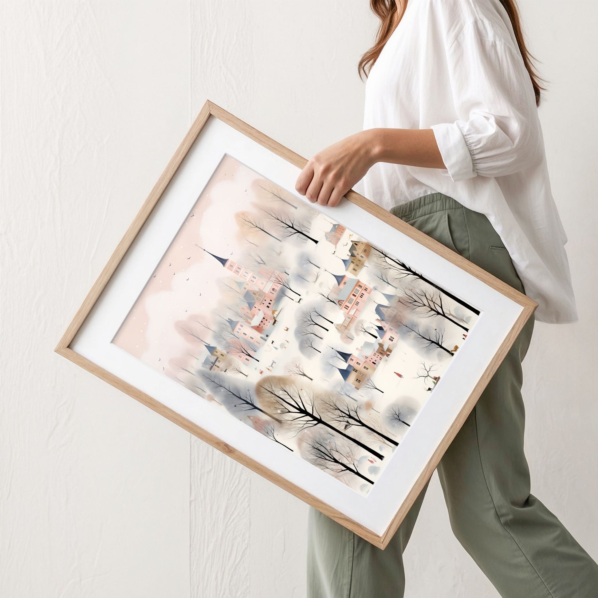Vinterbyen i Pastellskogen plakat med pastellfargede bygninger, snødekte trær og vinterlig bylandskap. Illustrasjon viser plakat med passepartout i eik ramme.