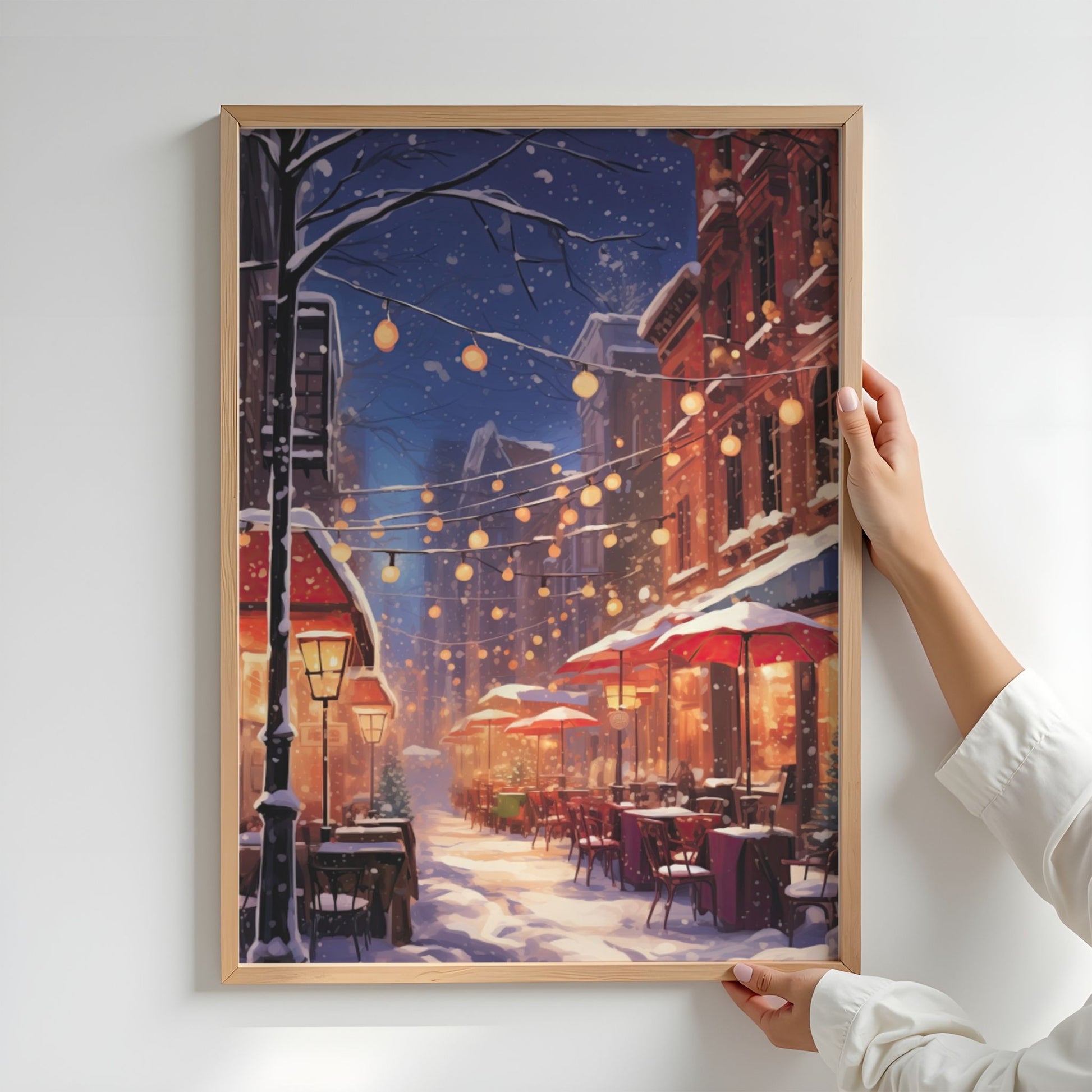 Vinterkveld i Kafégaten plakat med lyslenker, snødekte kafébord og varme vinterlys. Illustrasjon viser plakat uten hvit kantlinje i eik ramme.