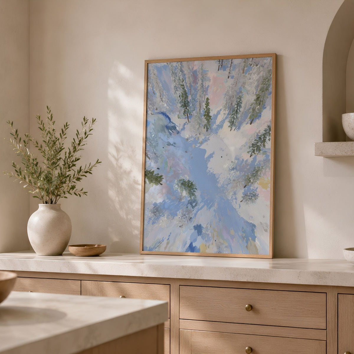 Winter Stillness plakat med snødekt skog plassert på lys kjøkkenbenk i minimalistisk interiør